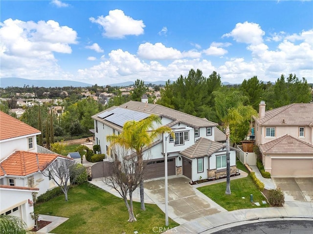 view of front of home with a tile roof, driveway, a front lawn, and fence