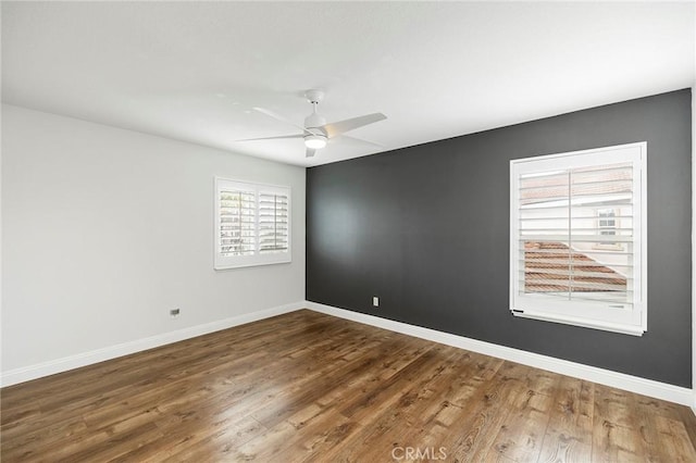 unfurnished room with a ceiling fan, baseboards, and wood finished floors