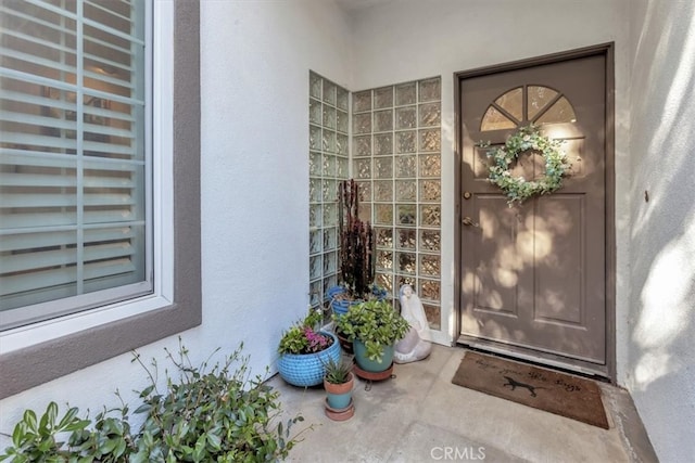 entrance to property featuring stucco siding