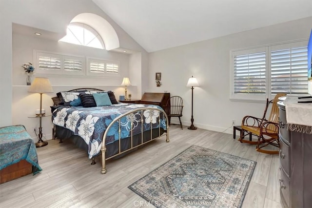 bedroom with light wood-style floors, lofted ceiling, and multiple windows