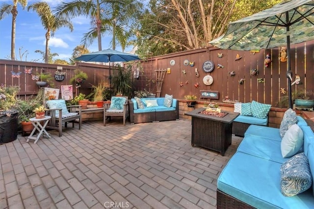 view of patio / terrace featuring a fenced backyard and an outdoor living space with a fire pit