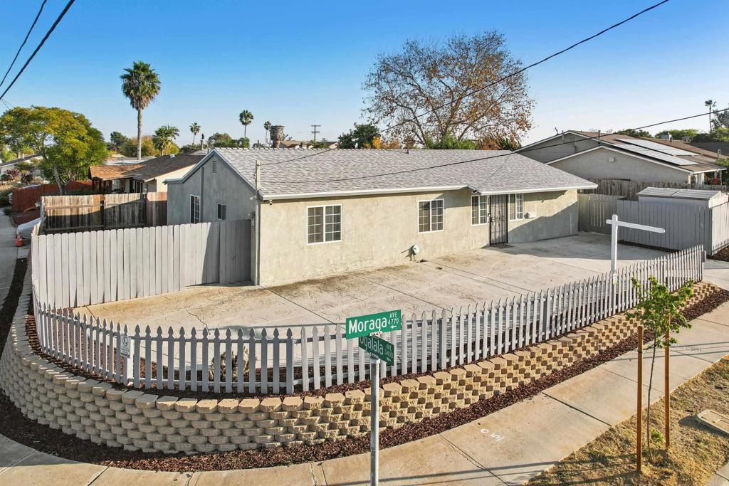 view of front of property with a patio, roof with shingles, fence, and stucco siding