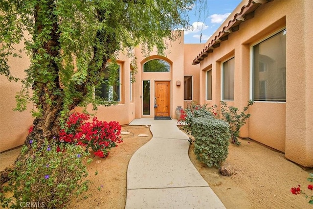 entrance to property featuring stucco siding