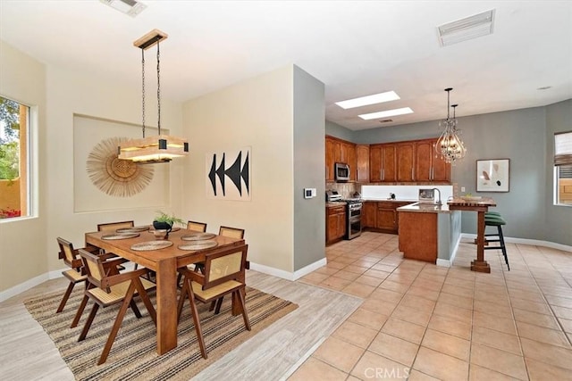 dining space with light tile patterned floors, baseboards, visible vents, and a chandelier