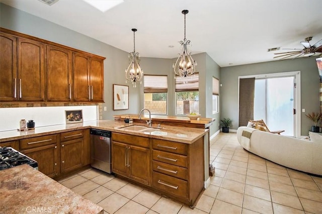 kitchen featuring decorative light fixtures, light tile patterned flooring, a sink, dishwasher, and a peninsula