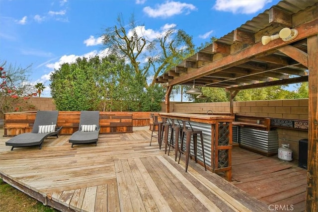 wooden deck featuring outdoor dry bar and a fenced backyard