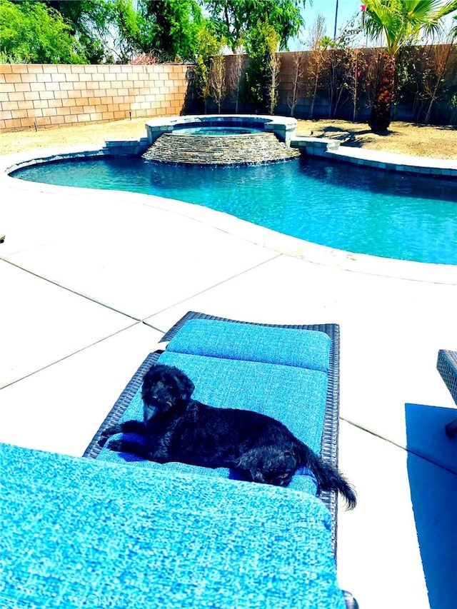 view of pool with a pool with connected hot tub and a fenced backyard