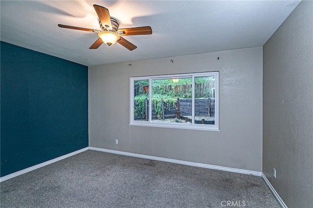 empty room with ceiling fan, carpet floors, and baseboards