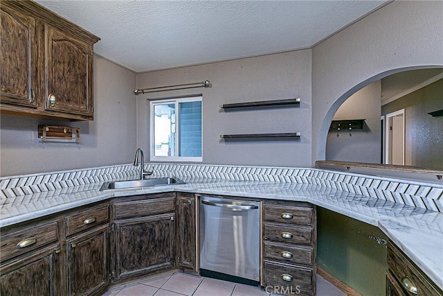 kitchen featuring dishwasher, light countertops, a sink, and dark brown cabinetry