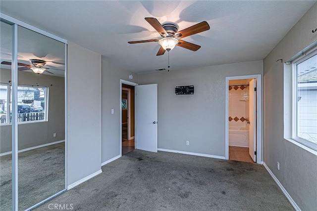 unfurnished bedroom featuring ensuite bathroom, ceiling fan, visible vents, baseboards, and carpet