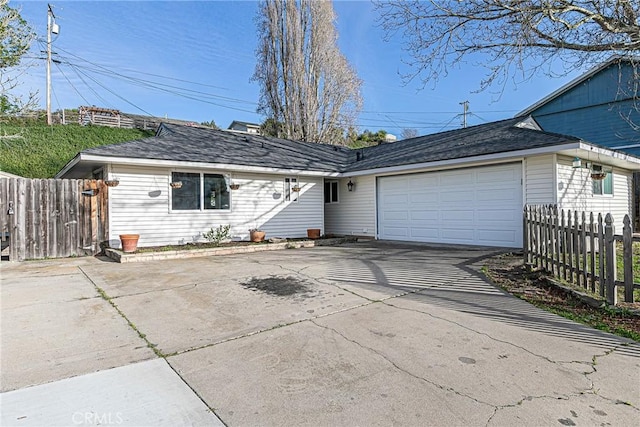 ranch-style home with an attached garage, fence, and concrete driveway