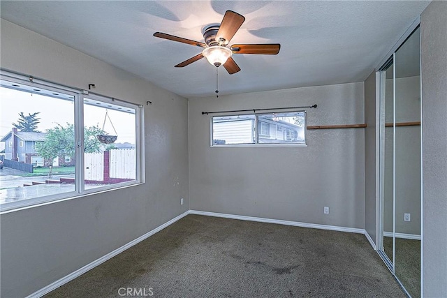 unfurnished bedroom featuring a ceiling fan, a closet, carpet flooring, and baseboards