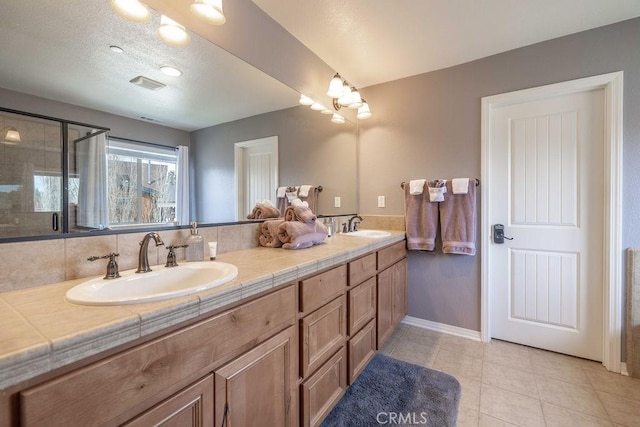 full bath featuring a stall shower, visible vents, a sink, and tile patterned floors