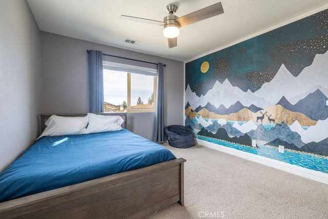 bedroom featuring ceiling fan, carpet floors, visible vents, and an accent wall