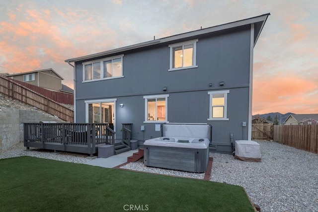 back of house featuring a hot tub, a lawn, a fenced backyard, a deck, and cooling unit