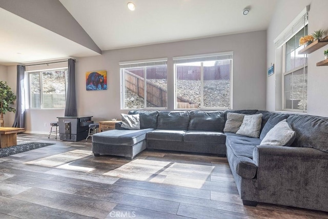 living room featuring a wood stove, wood-type flooring, and lofted ceiling