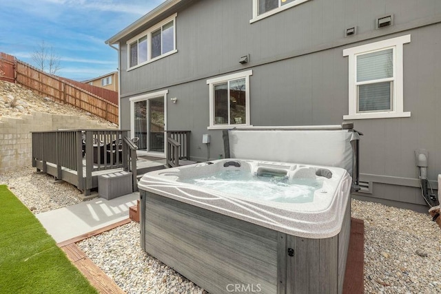 view of patio featuring fence, a hot tub, and a wooden deck