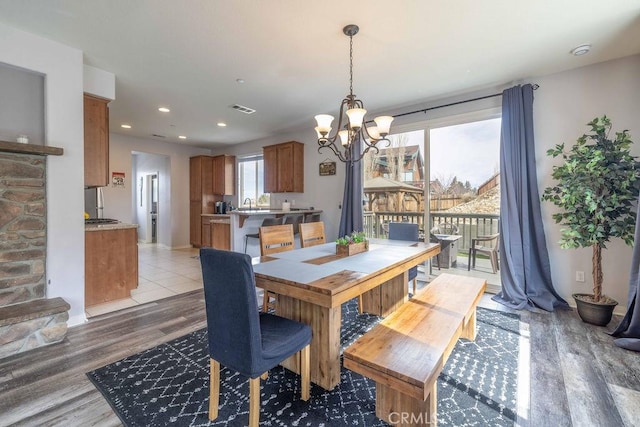 dining room with recessed lighting, light wood-type flooring, visible vents, and an inviting chandelier