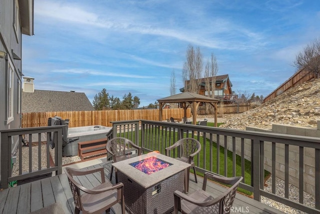 wooden terrace featuring a hot tub, an outdoor fire pit, a fenced backyard, and a gazebo