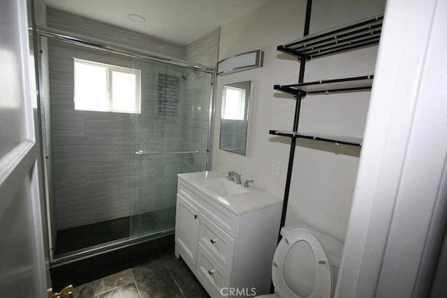 bathroom featuring toilet, tile patterned floors, a shower stall, and vanity