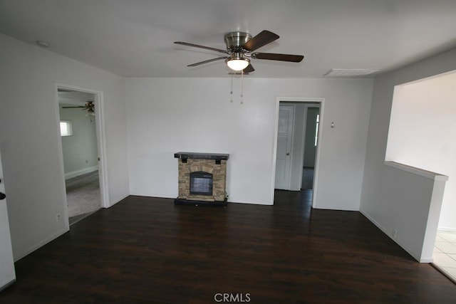 unfurnished living room with a ceiling fan, visible vents, a fireplace, and wood finished floors