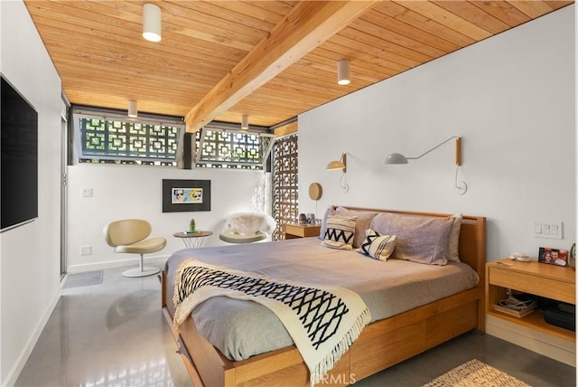 bedroom featuring concrete flooring, beamed ceiling, wood ceiling, and baseboards