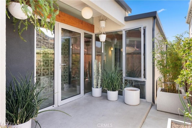 doorway to property featuring a patio and stucco siding