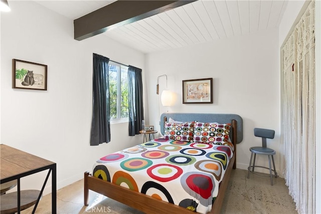 bedroom featuring beamed ceiling and baseboards