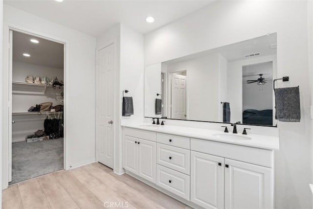 32345 Jeter Ln, Menifee, CA 92584 - bathroom with double vanity, wood finished floors, a ceiling fan, recessed lighting, and a walk in closet