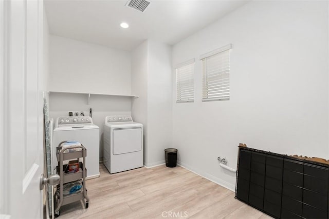 laundry area with washing machine and dryer, laundry area, visible vents, baseboards, and light wood finished floors