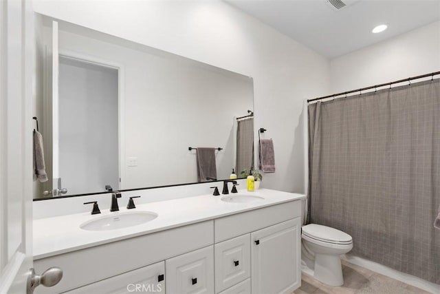 bathroom featuring double vanity, a shower with curtain, toilet, and a sink