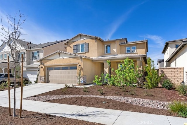 view of front of house with an attached garage, a tile roof, concrete driveway, and stucco siding