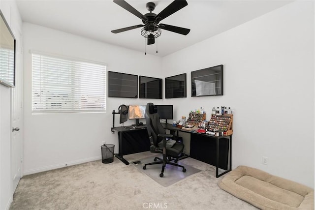 carpeted office with ceiling fan and baseboards