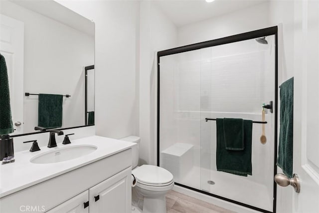 full bath featuring vanity, a shower stall, and toilet