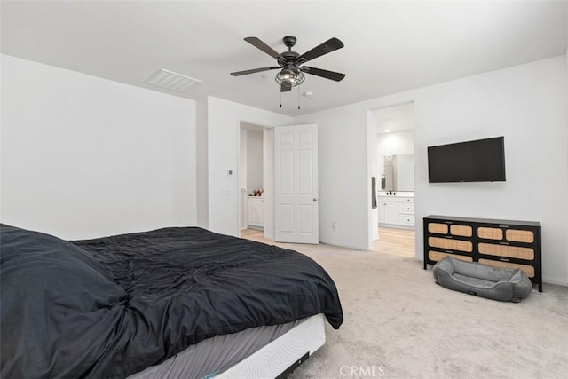 bedroom featuring light colored carpet, ceiling fan, visible vents, and ensuite bathroom