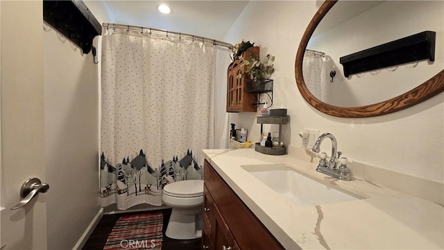 bathroom featuring toilet, curtained shower, baseboards, and vanity