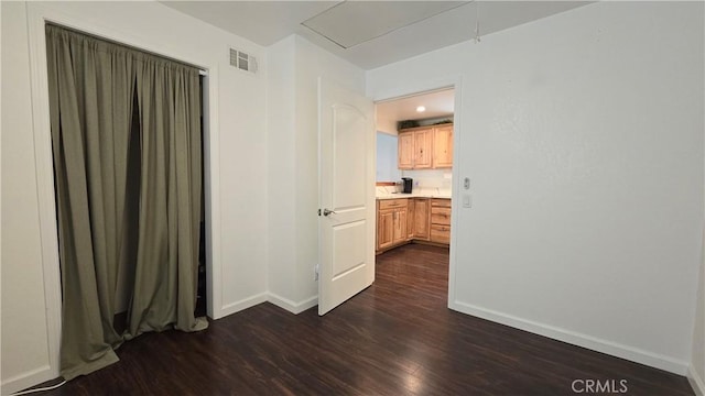 empty room featuring dark wood-style flooring, recessed lighting, visible vents, and baseboards