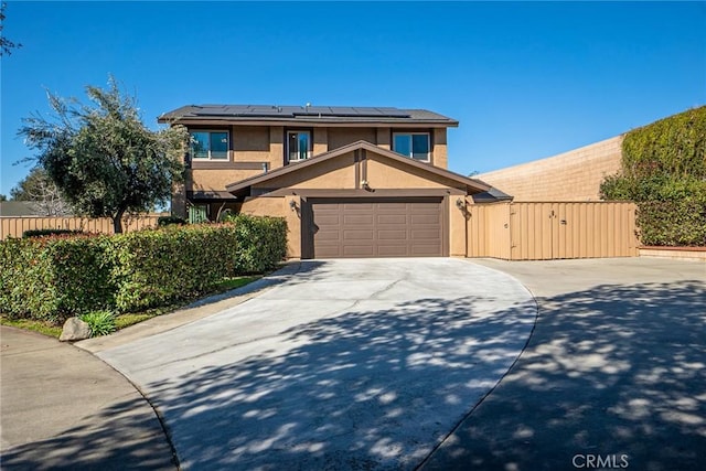 view of front of house with a garage, solar panels, fence, a gate, and stucco siding