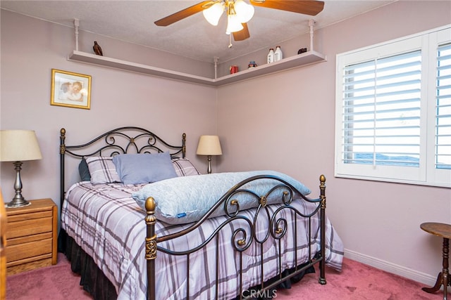 bedroom featuring carpet, multiple windows, baseboards, and a ceiling fan