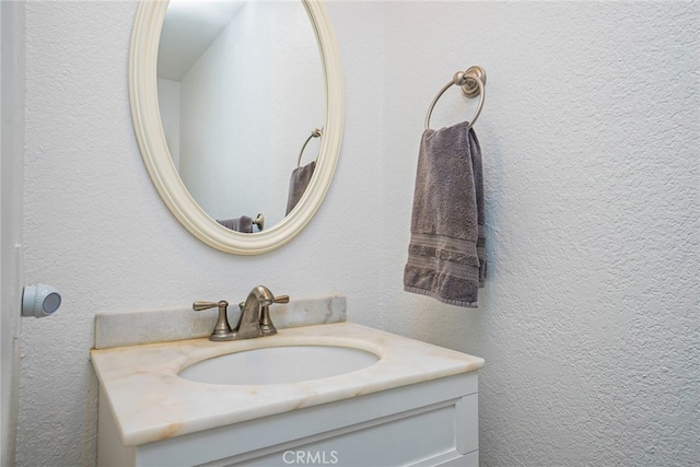 bathroom featuring a textured wall and vanity