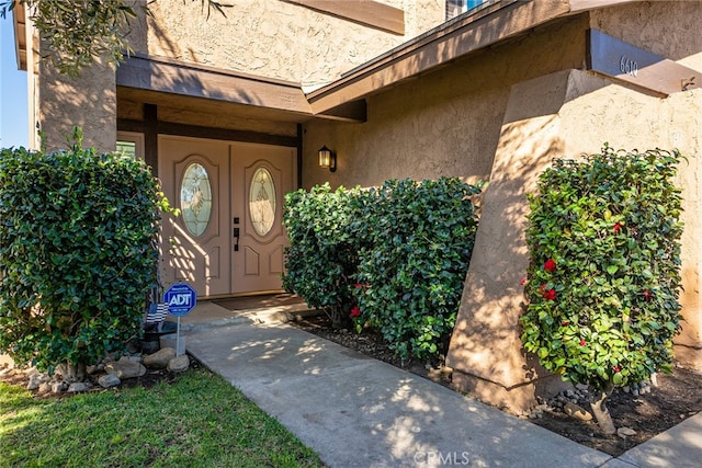 property entrance with stucco siding