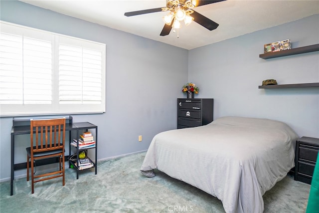 carpeted bedroom with ceiling fan and baseboards