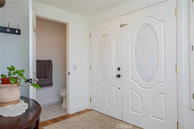 foyer featuring baseboards and light wood-style floors