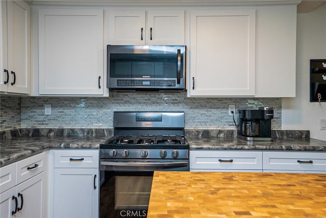 kitchen featuring white cabinets, tasteful backsplash, stainless steel appliances, and wooden counters