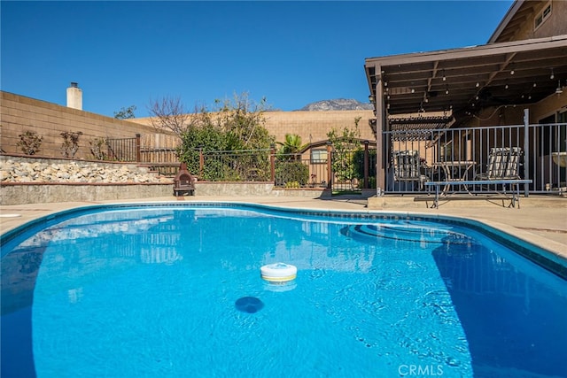 view of pool featuring a mountain view, a fenced backyard, and a fenced in pool