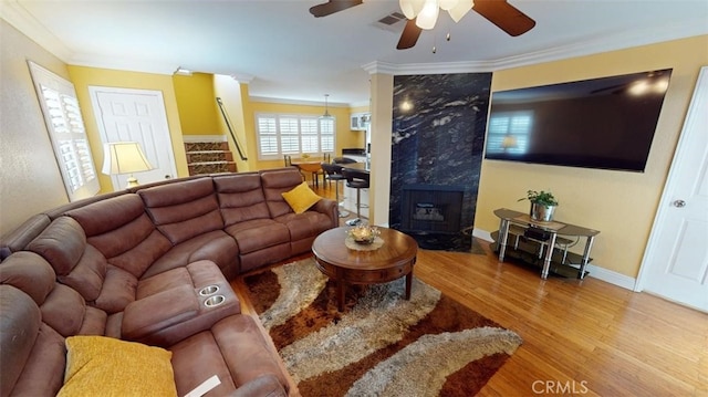 living room featuring stairs, ornamental molding, wood finished floors, and baseboards