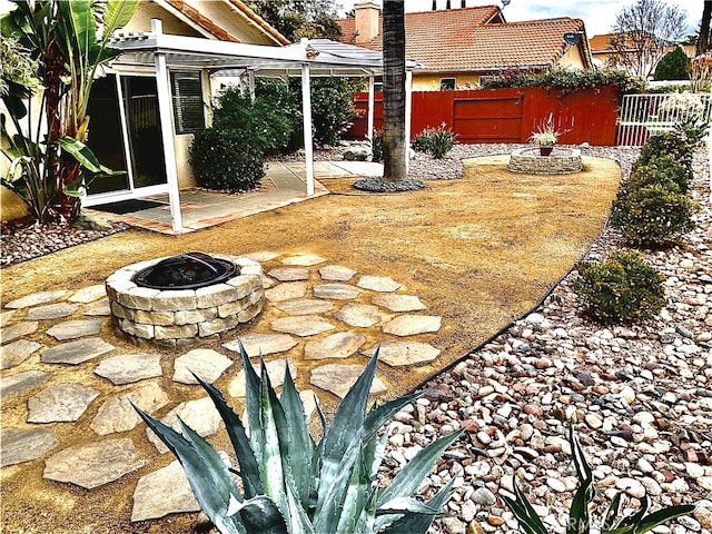 view of yard featuring fence, a fire pit, and a patio