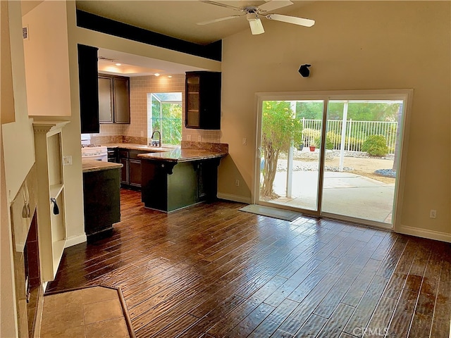 bar with a sink, tasteful backsplash, baseboards, and wood finished floors