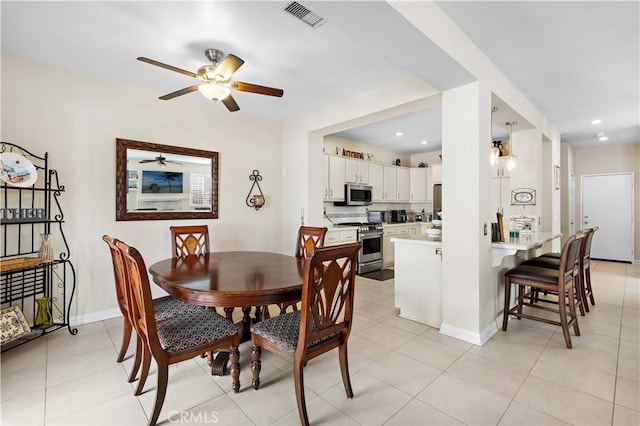 dining room featuring light tile patterned floors, baseboards, and visible vents