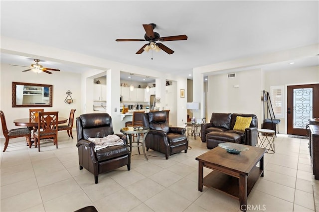 living room with a ceiling fan, visible vents, and light tile patterned floors